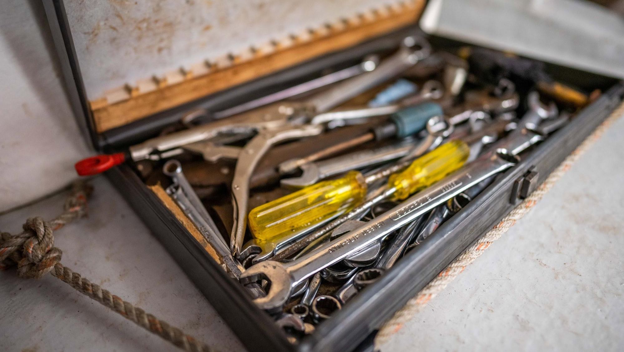 Åpen verktøykasse med skiftenøkler og skrutrekkere i båt.